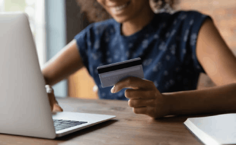 happy smiling young African female shopper hold credit card pay online | Total Floors